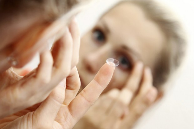 close up of a woman putting contact lens in her eye 